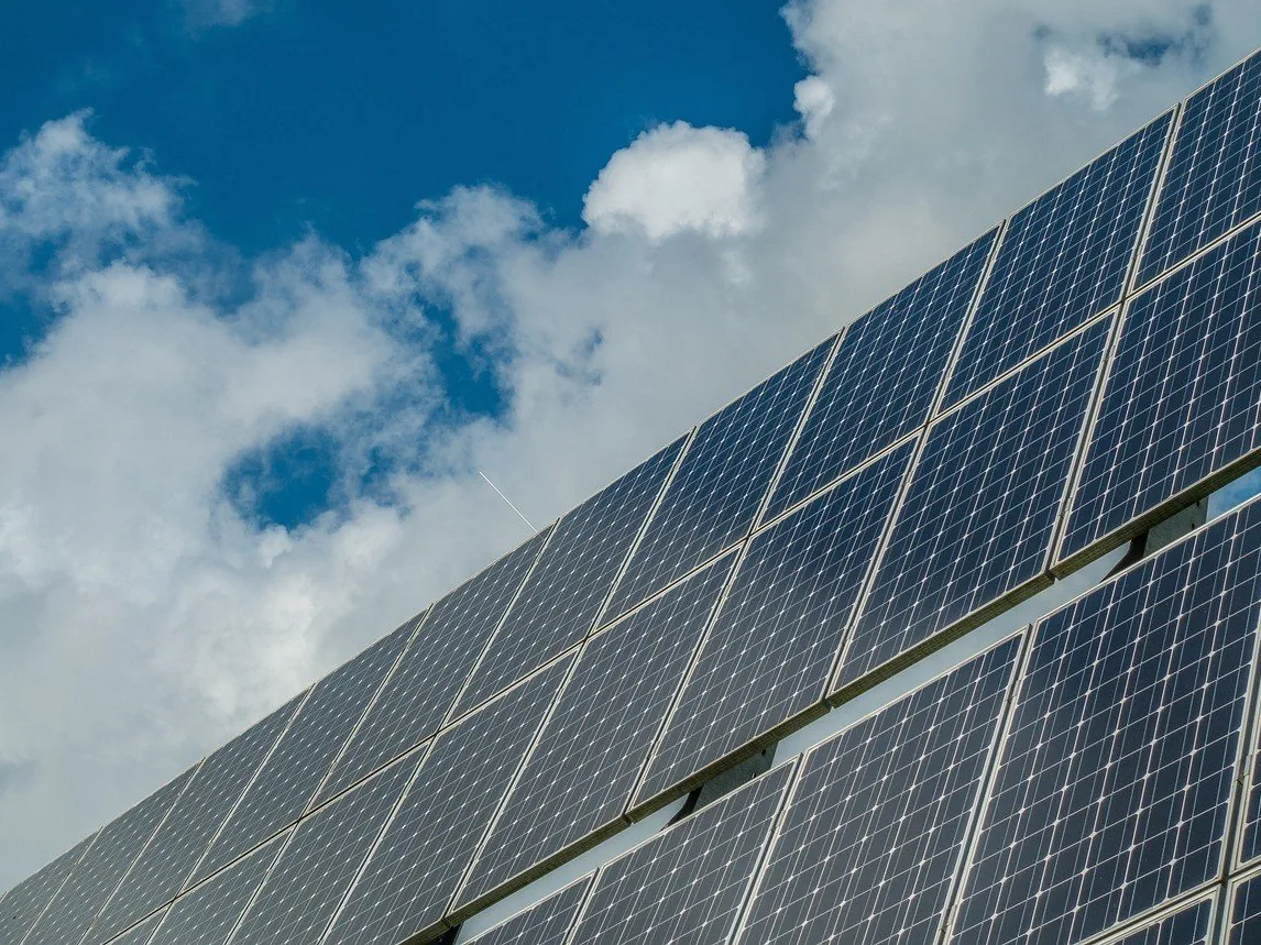 A solar array seen from below against the sky