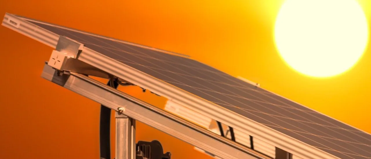 A tracker-mounted solar array against a low evening sun