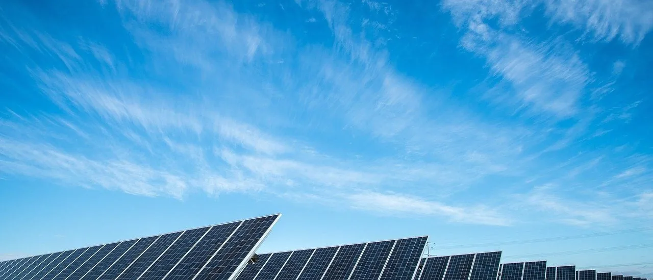 Rows of solar modules stretching to the horizon under a clear sky